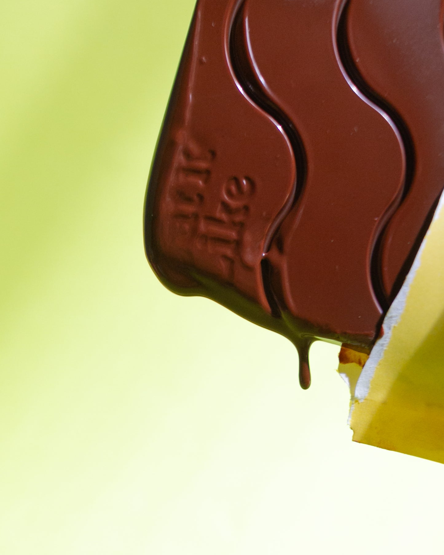 Eat it like chocolate melting in opened yellow wrapped on green background